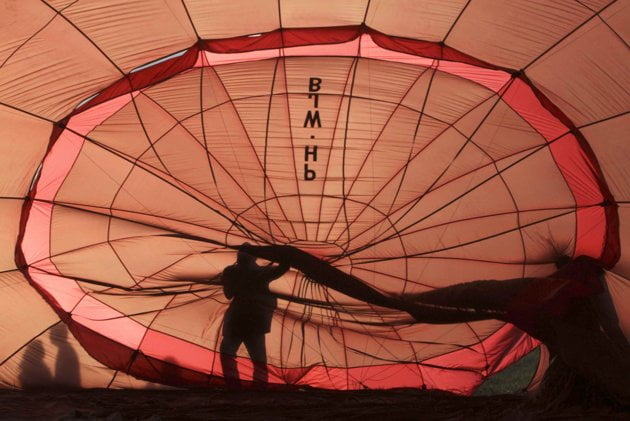 a worker fixes a balloon before it is flown a worker fixes a balloon before it is flown