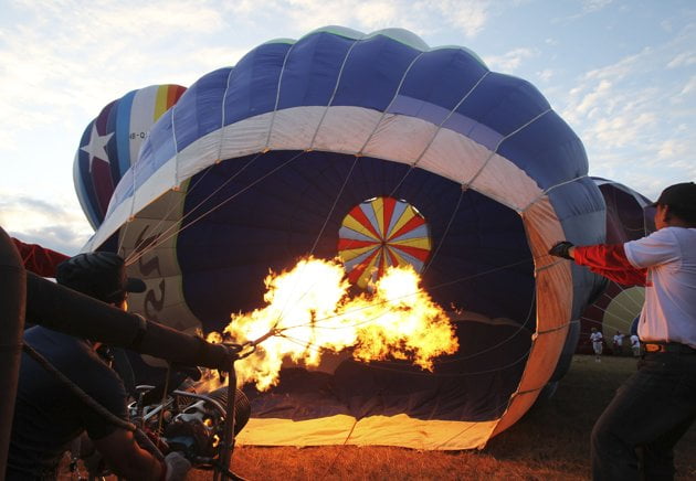 a participant inflates a balloon before it was flown during the festival a participant inflates a balloon before it was flown during the festival